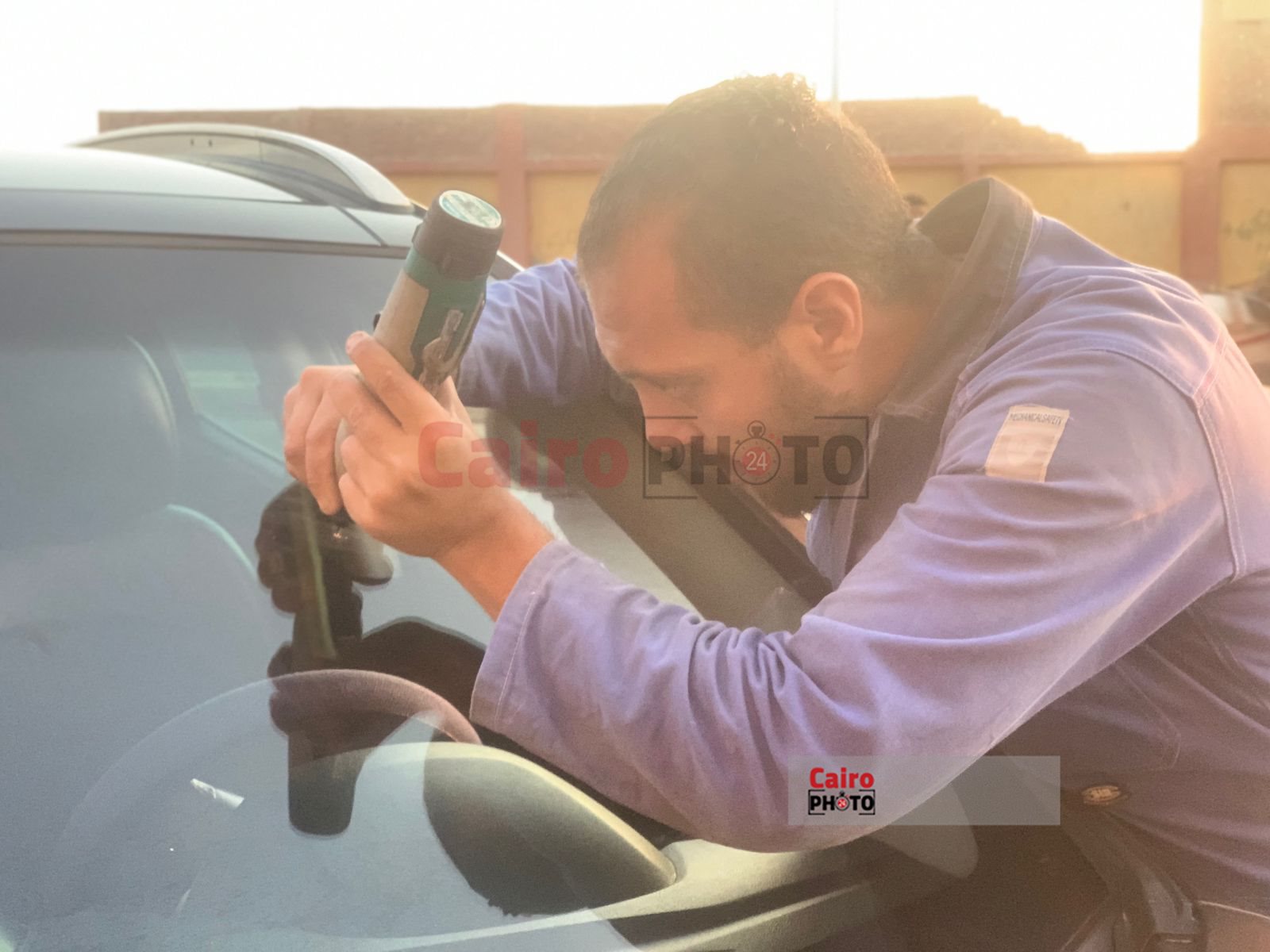 شاب يعمل في اصلاح زجاج السيارات ببورسعيد 