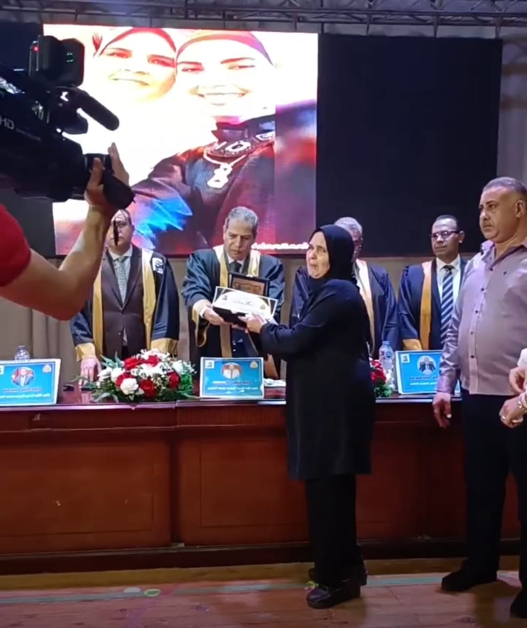 الأم خلال تسلمها تكريم اسم ابنتها الراحلة قبل تخرجها