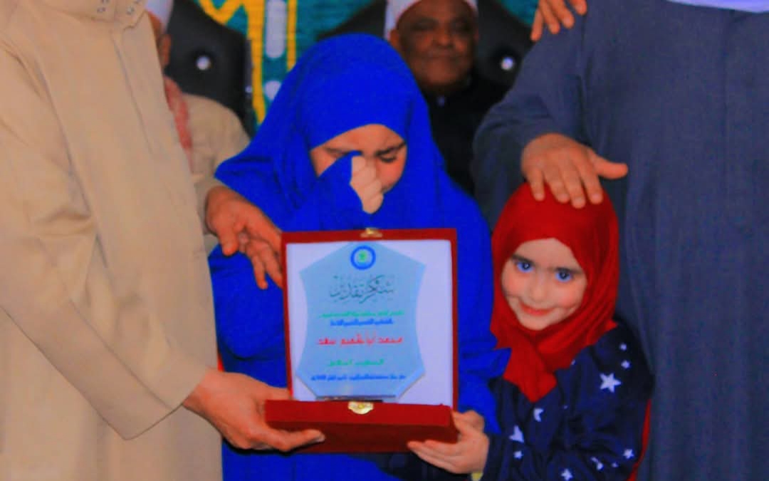 استلام الطفلة وشقيقتها درع والدها الراحل في حفل حفظة القرآن الكريم بالمنوفية