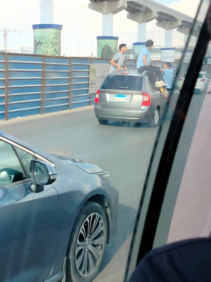 أطفال يستقلون سطح سيارة ملاكي بشارع التسعين في التجمع الخامس