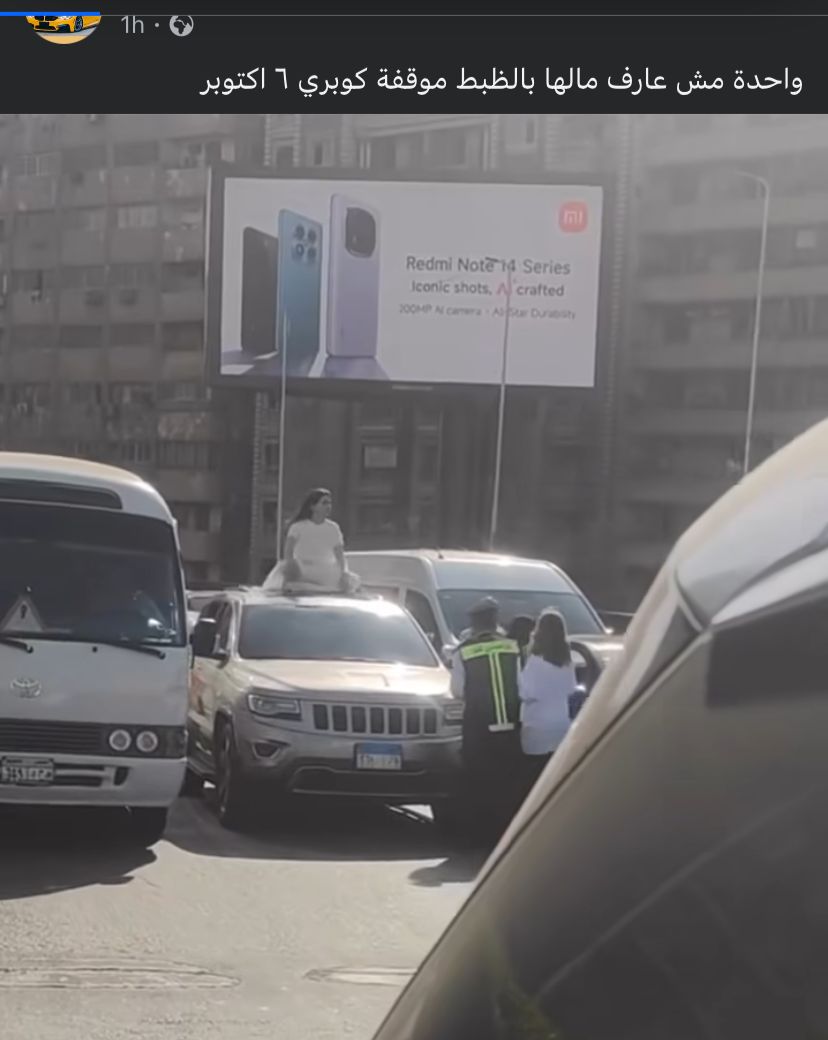 فتاة تجلس أعلى السيارة بكوبري أكتوبر 