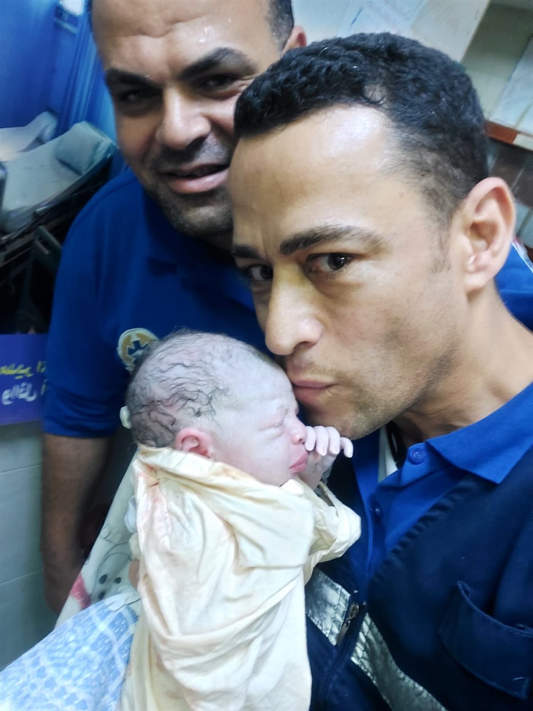 طاقم سيارة الإسعاف مع المولود بمحطة القطار