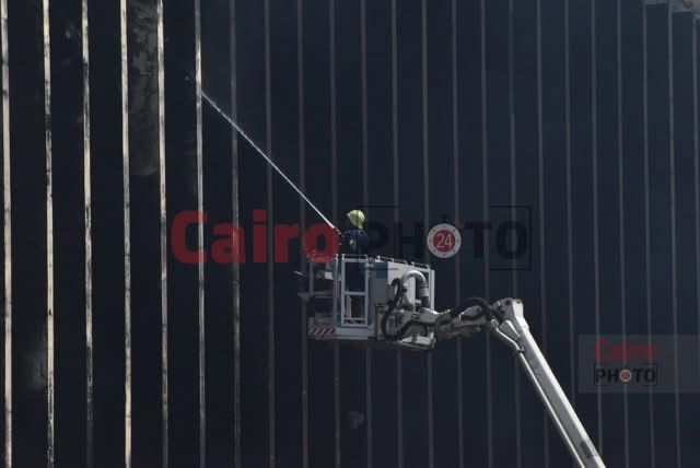 أحد رجال الحماية المدنية يحاول إخماد حريق سنترال رمسيس