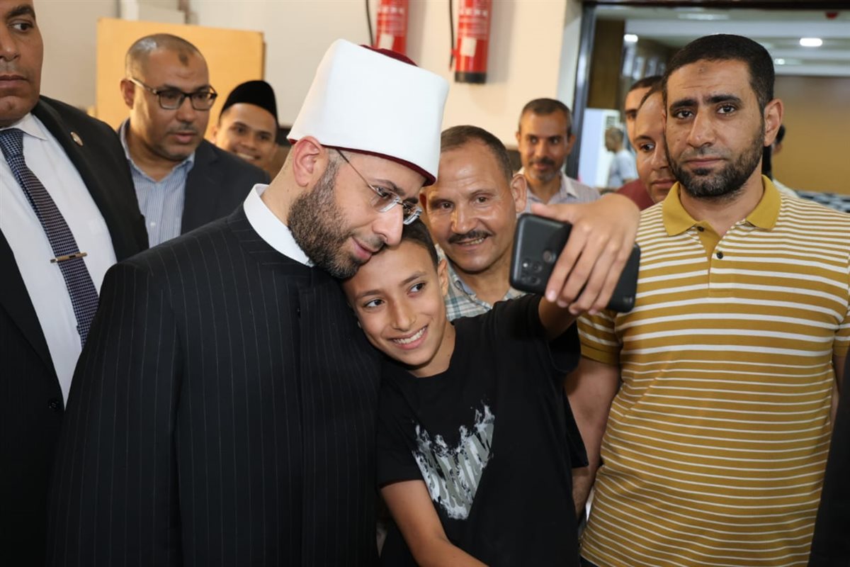 وزير الأوقاف يلتقط سيلفي مع أحد الصغار ويستمع لأخر خلال مناقشة رسالة ماجستير لإمام وخطيب بالوزارة&nbsp;
