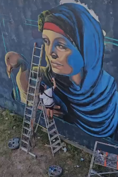 الفنانة التشكيلية المصرية ندى مرجاوي أثناء رسم الجرافيتي