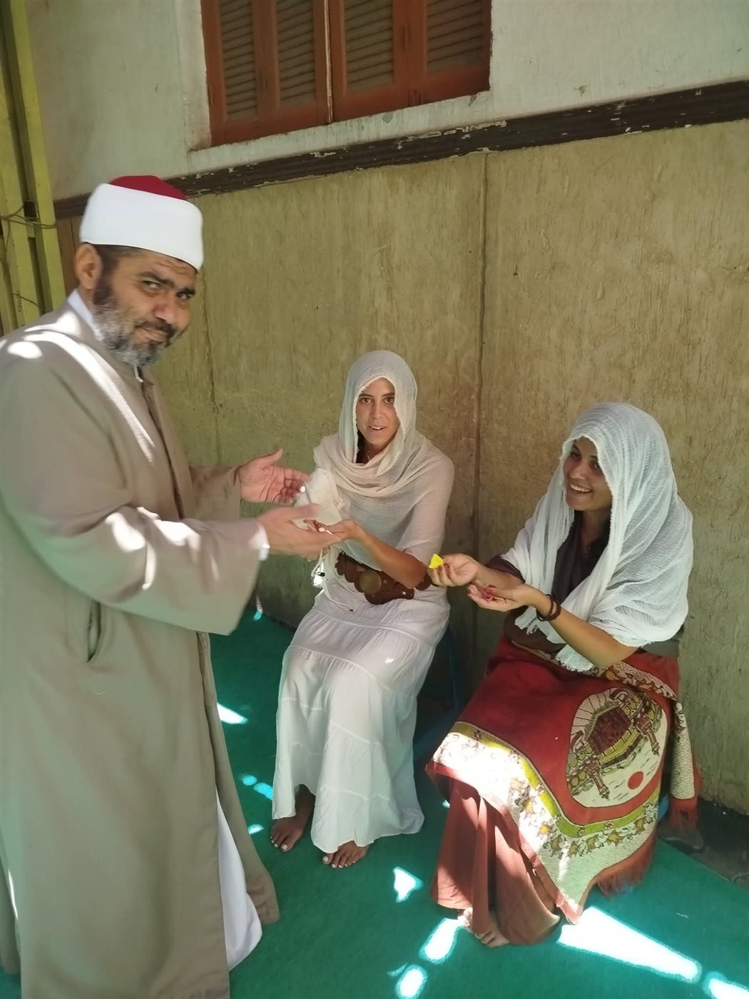 الشيخ يقدم الحلوى للسائحتين