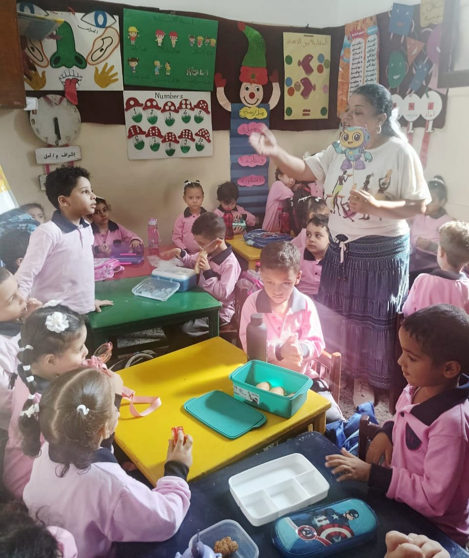 معلمي مدارس القاهرة يستقبلون الطلاب في أول أيام الدراسة بالورود والأعلام