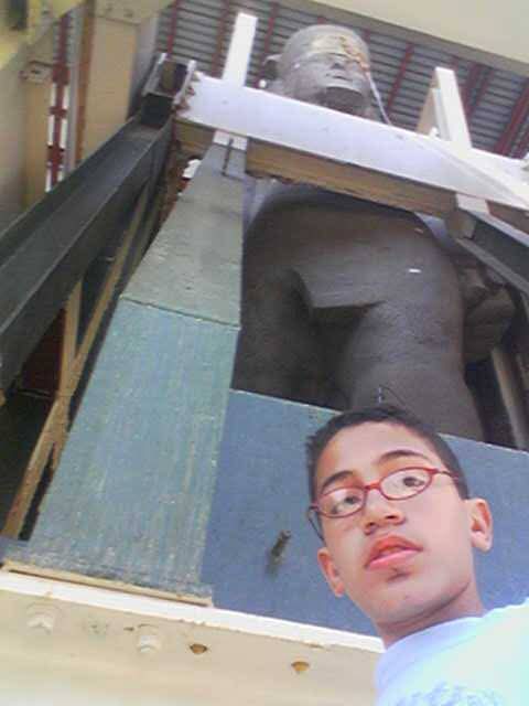 الباحث الأثري مع تمثال الملك رمسيس الثاني 