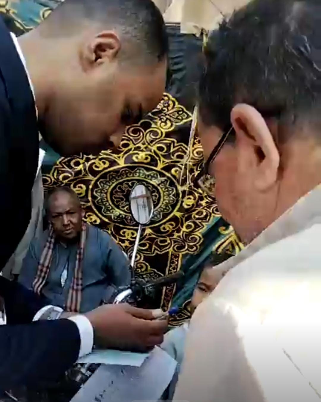 رئيس لجنة يساعد مسن من ذوي الهمم للإدلاء بصوته 