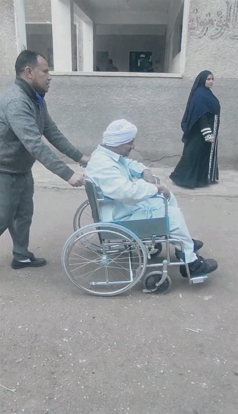 زوجة ترافق زوجها على كرسي متحرك للإدلاء بصوته