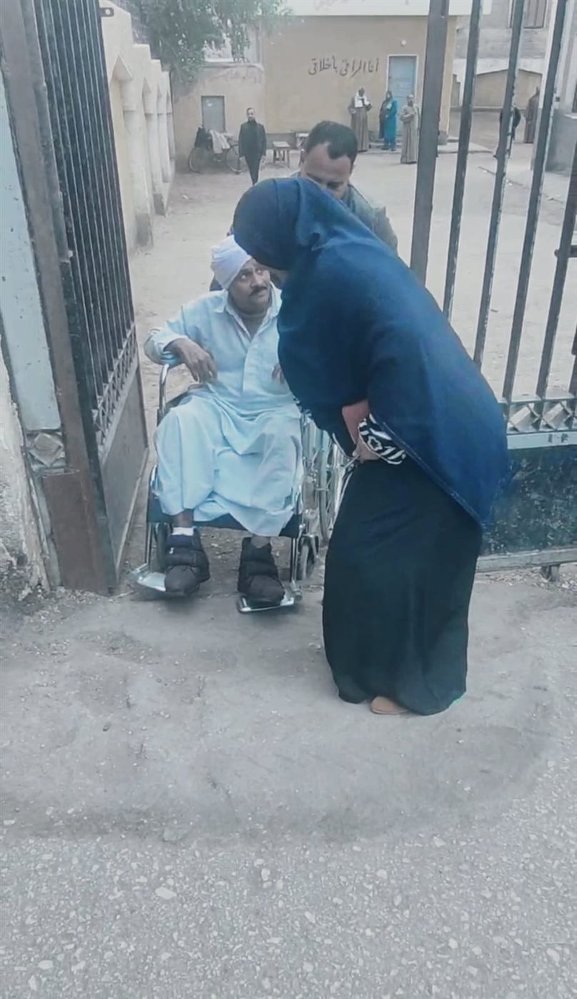 زوجة ترافق زوجها على كرسي متحرك للإدلاء بصوته
