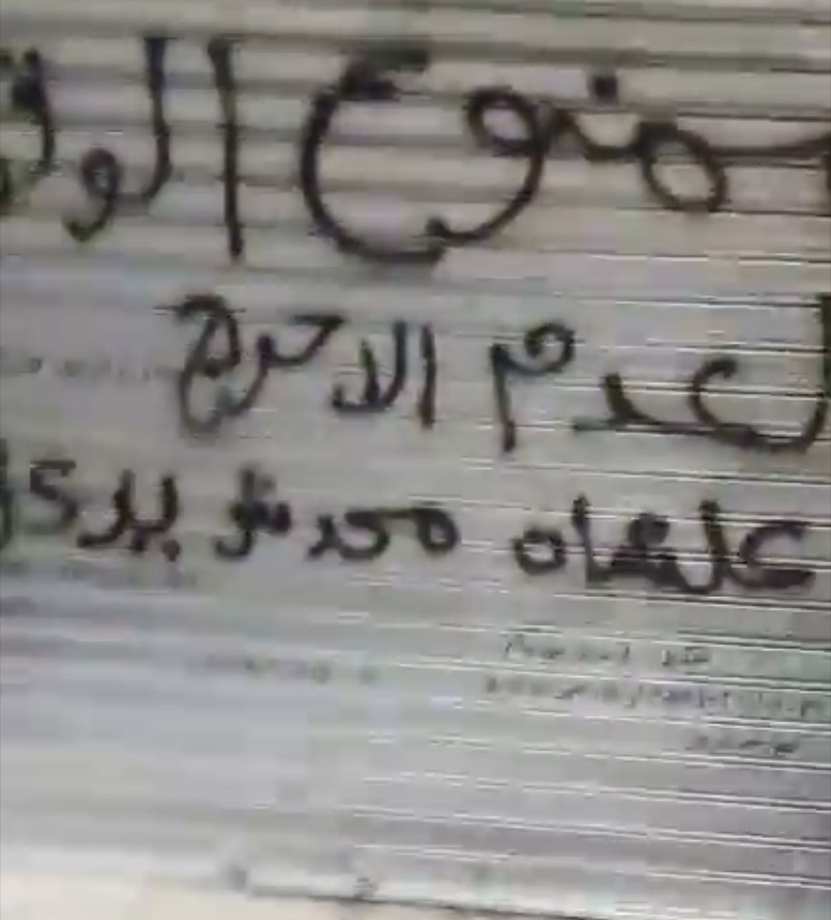 عبارات تهديد على باب أحد المحلات 