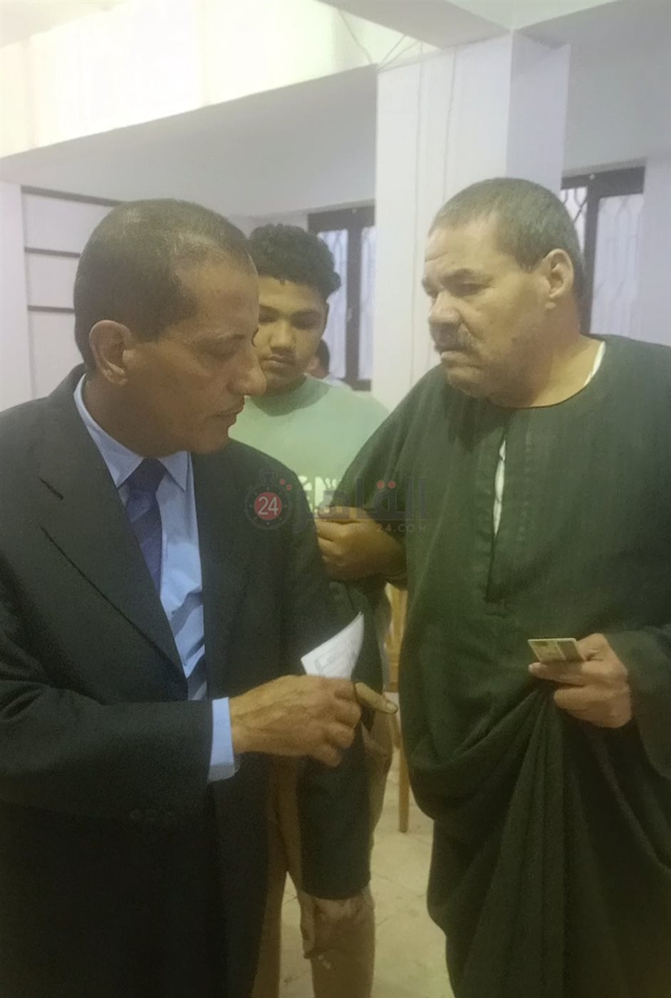 مستشار يساعد كفيفا للإدلاء بصوته في إحدى لجان العجميين بانتخابات النواب بالفيوم