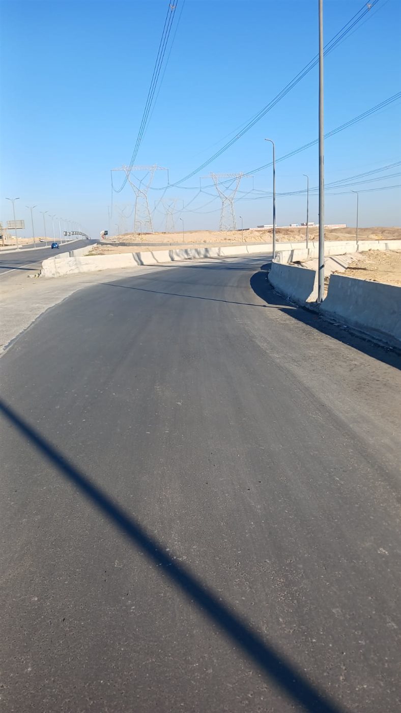 هبوط أرضى بطبقة الأسفلت الملاصق لسور أحد الكباري بطريق السويس