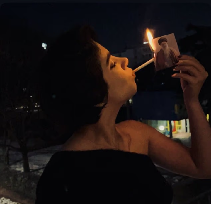 نساء إيرانيات يشعلن السجائر بصور المرشد