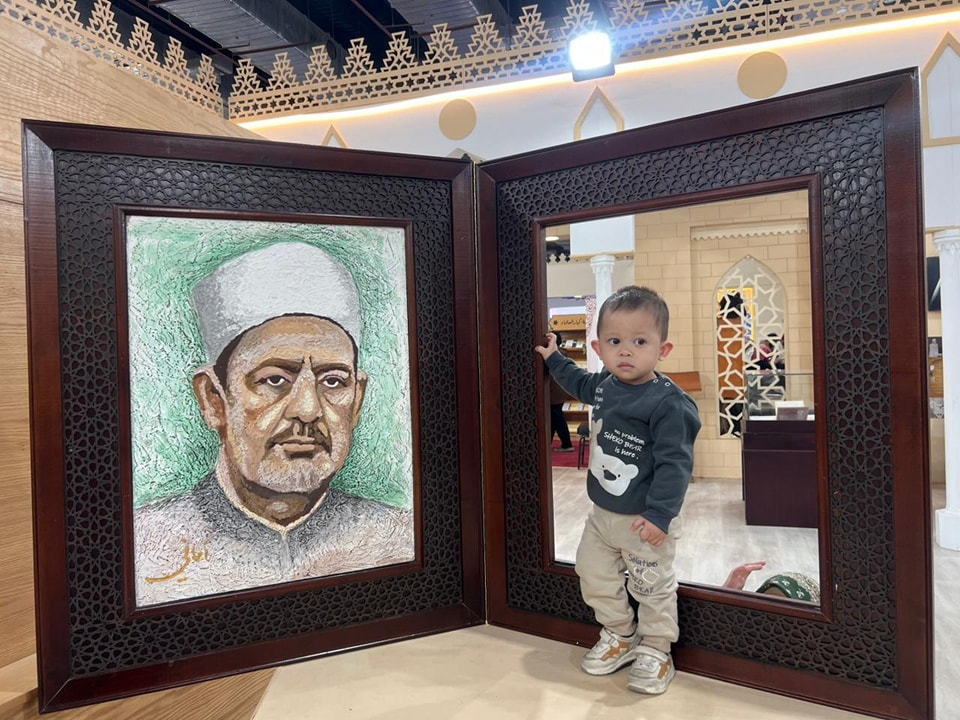 تعجب الزوار.. صورة للذكرى مع الإمام الطيب داخل برواز الكتاب المفتوح في جناح الأزهر الشريف بمعرض الكتاب