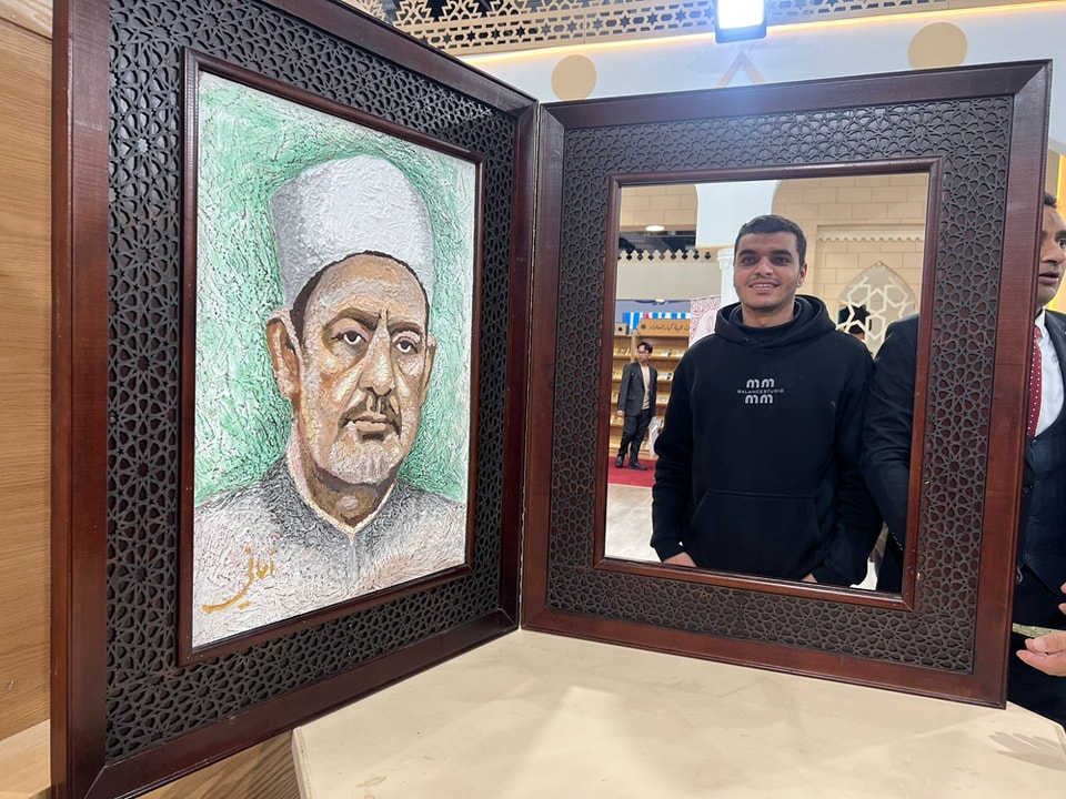 تعجب الزوار.. صورة للذكرى مع الإمام الطيب داخل برواز الكتاب المفتوح في جناح الأزهر الشريف بمعرض الكتاب