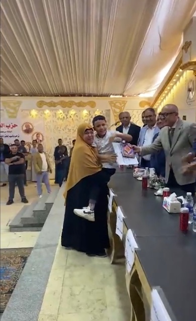 حملت إبنها على كتفها لتسلم تكريمة