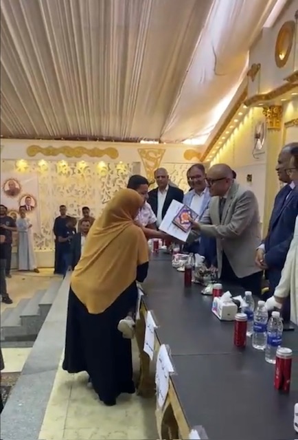 حملت إبنها على كتفها لتسلم تكريمة