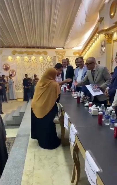 حملت إبنها على كتفها لتسلم تكريمة