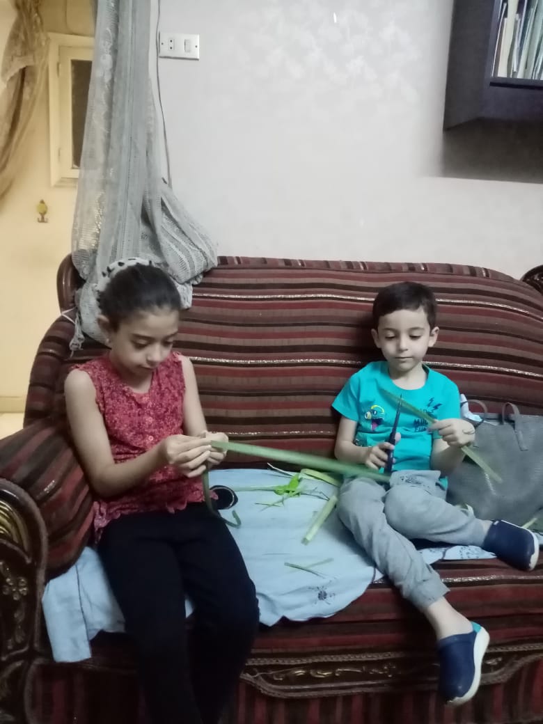 أطفال أسرة الدكتورة ماريان سليمان يصممون أشكالًا من السعف