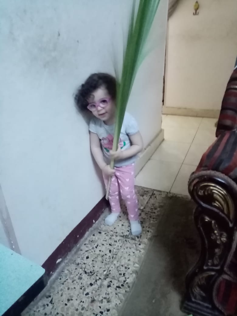 نجلة شقيق الدكتورة ماريان تحمل السعف احتفاءًا بالعيد