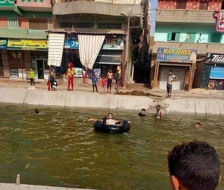 أحد شباب القرية يلهو في امياه على إطار سيارة