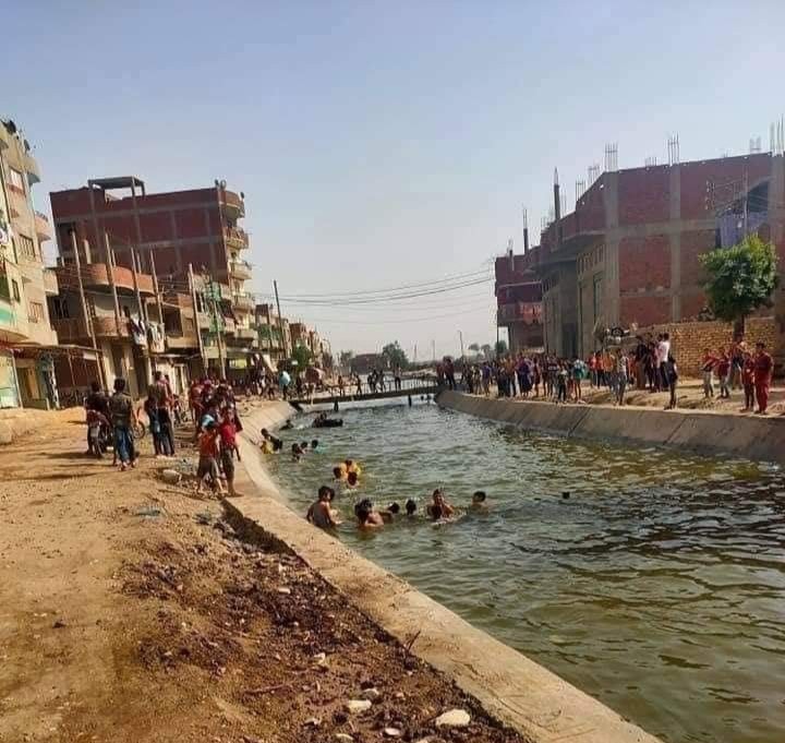 شباب وأطفال القرية يلهون في الترعة المبطنة