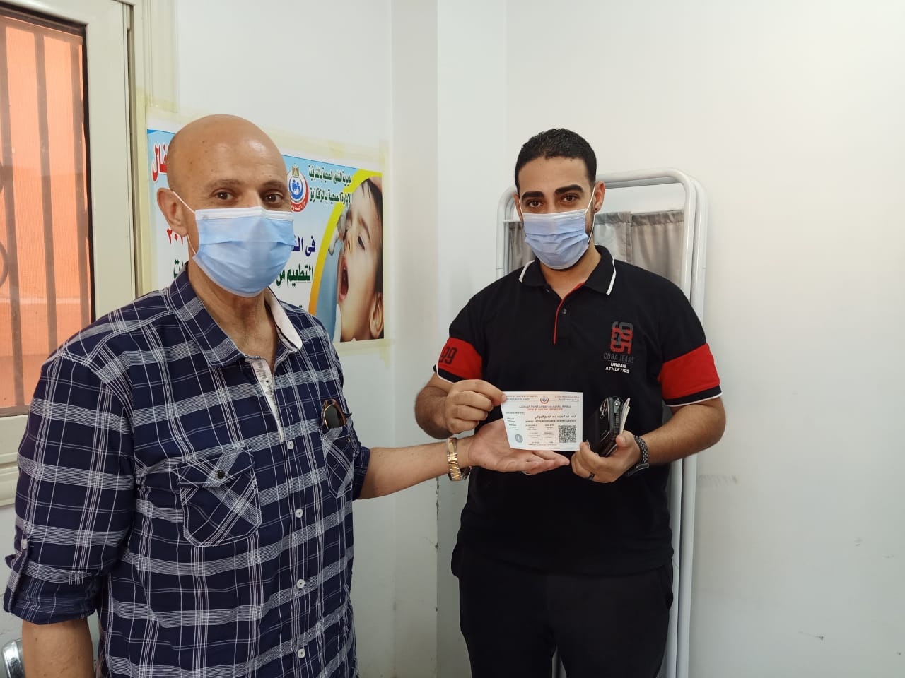 وكيل وزارة الصحة مع صاحب أول شهادة تطعيم ضد كورونا بالشرقية