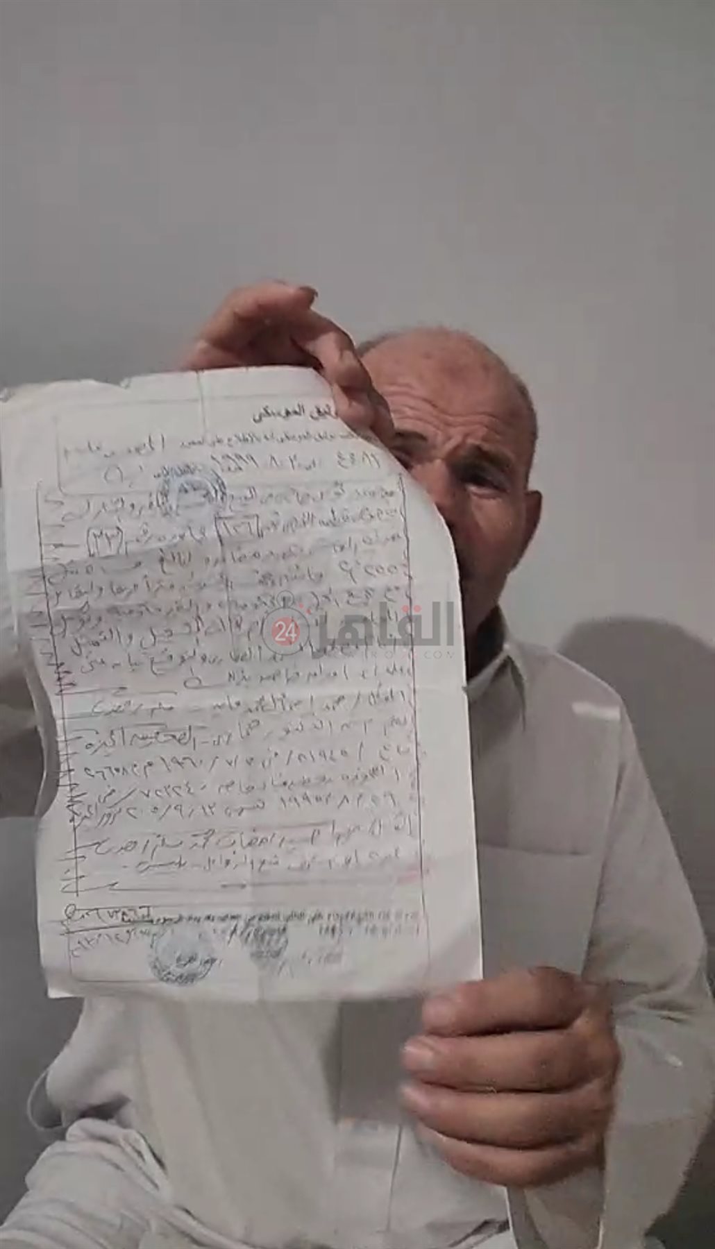 الأب ممسكًا بعقد توثيق منزله
