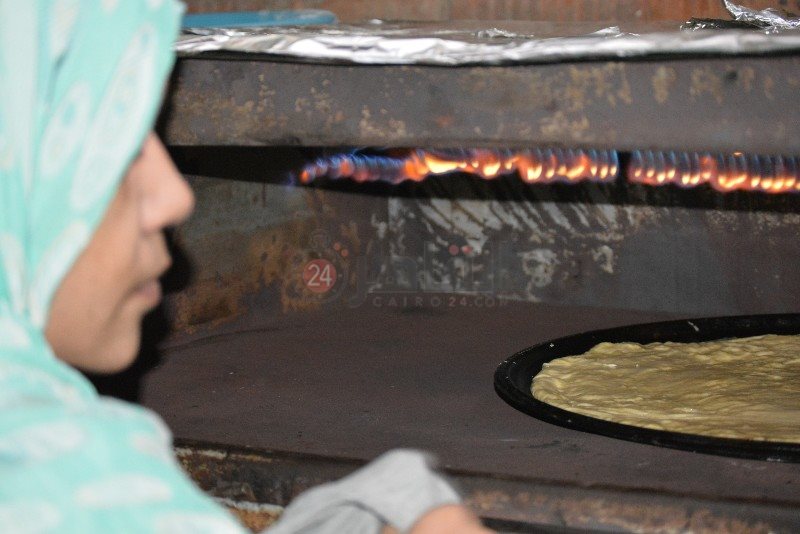 أم محمد أمام النار لصناعة الفطير 