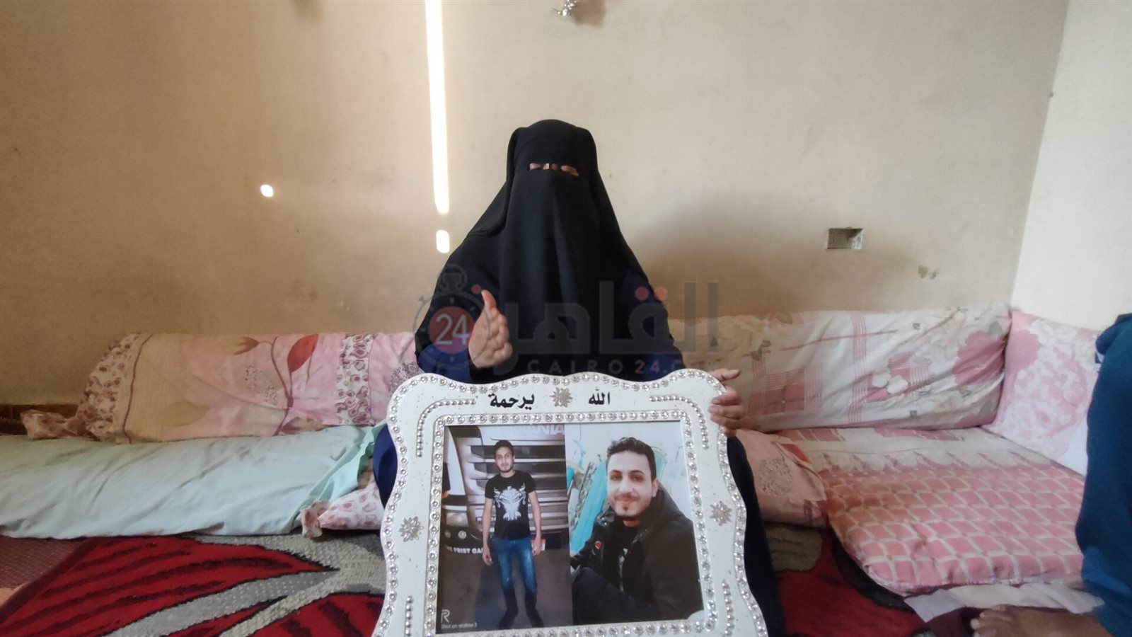 والدة المجني عليه تحمل صورته