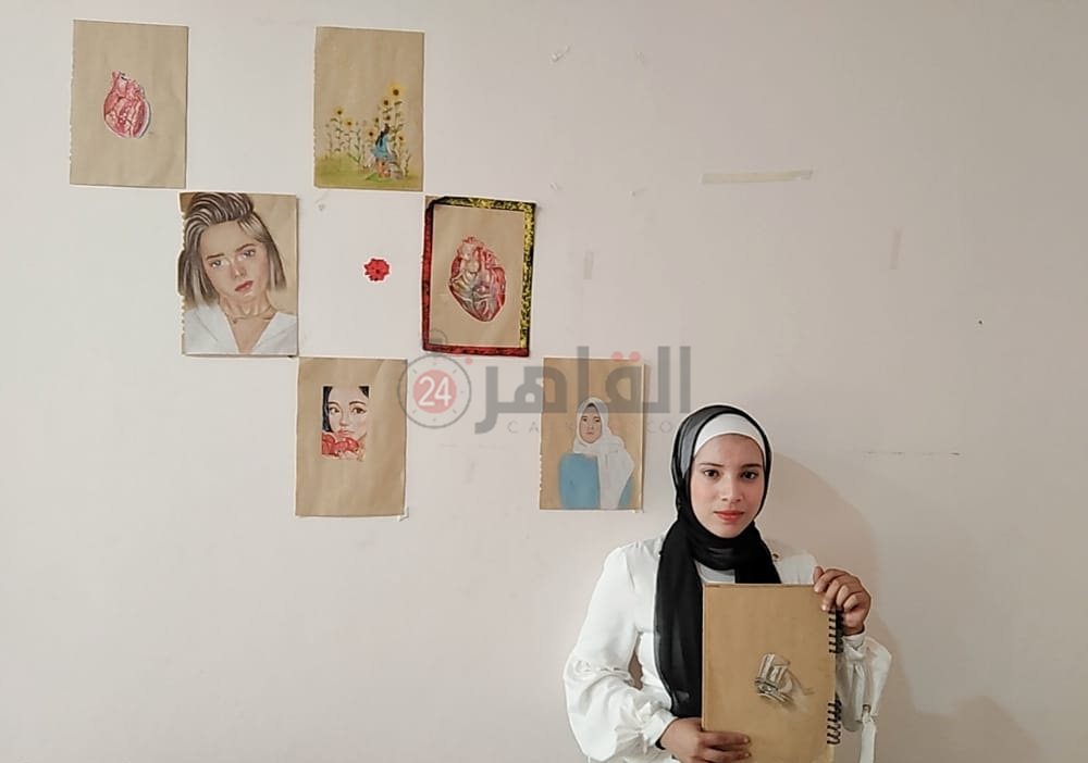 منة بجوار لوحات من رسمها الخاص