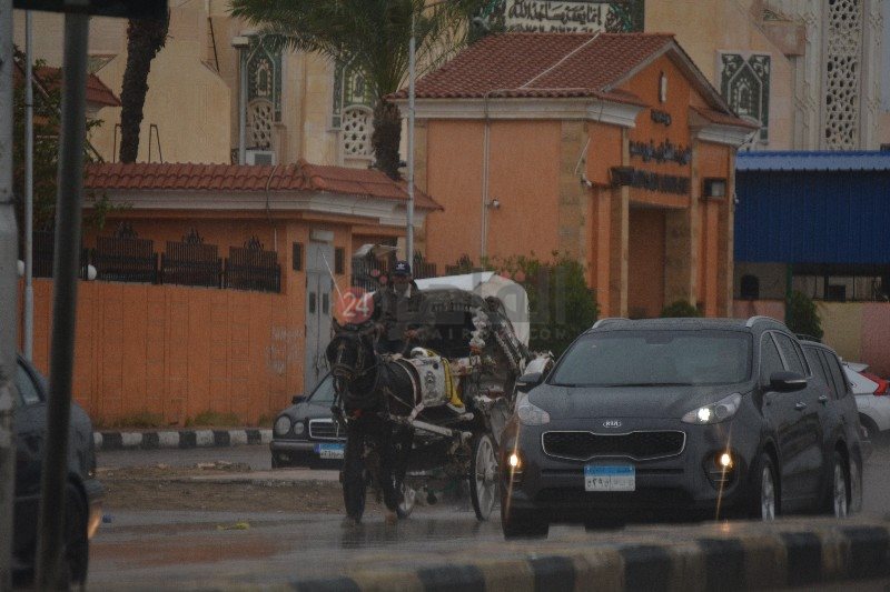 سائق عربة يسير وسط الأمطار 