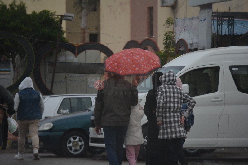 اسرة تحتمي بـ شمسية من الأمطار 