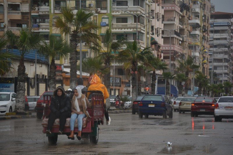 أسرة علي دراجة نارية رغم الأمطار 