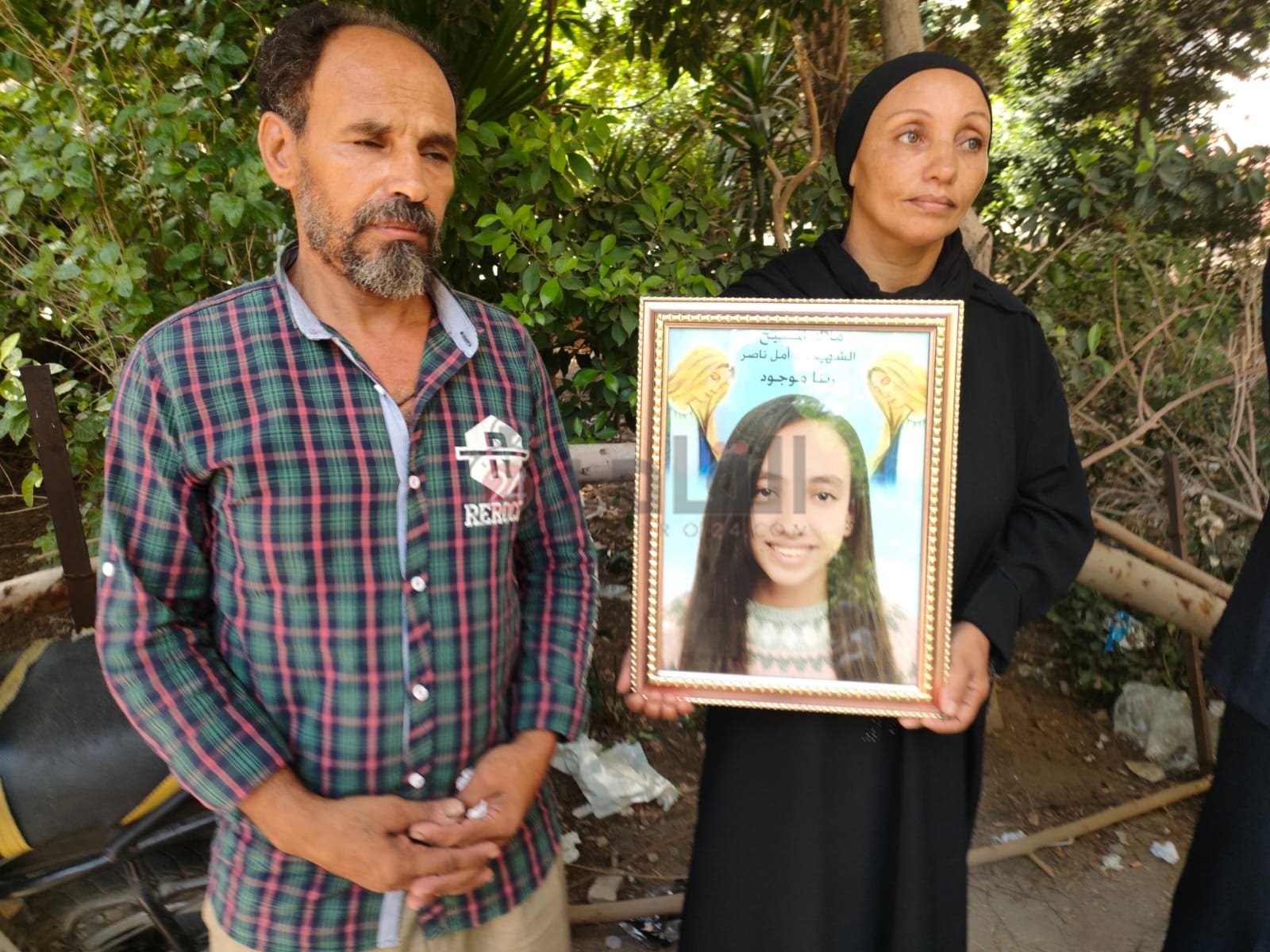 والدة أمل تحمل صورتها