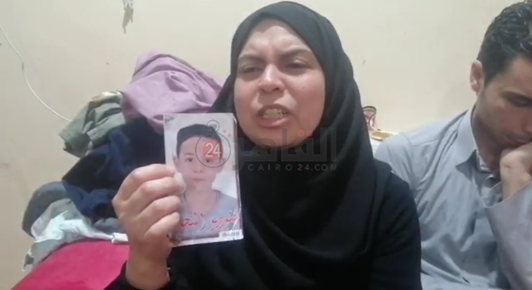 والدة ياسين تحمل صورته أثناء حديثها لـ القاهرة 24