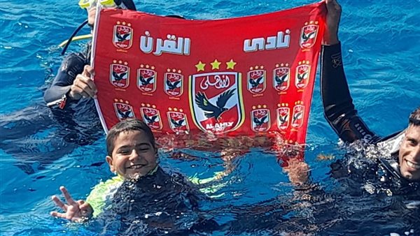 طفل يغطس بعلم الأهلي