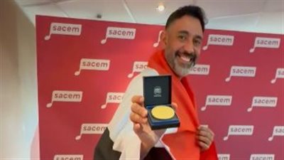 عمرو مصطفى يرفع علم مصر أثناء تكريمه من جمعية المؤلفين والملحنين العالمية 