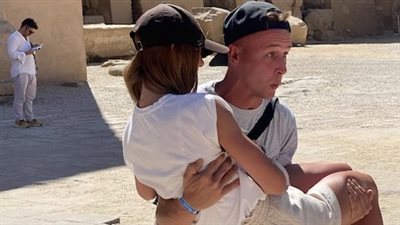 تعبيرا عن حبه.. سائح يحمل صديقته طوال زيارتهما لمعبد الكرنك بالأقصر 