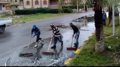 عمال النظافة يكسحون مياه الأمطار ببلطيم في كفر الشيخ 