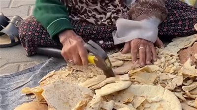 رحمة رغم النزوح.. سيدة فلسطينية تطحن الخبز لإطعام الطيور