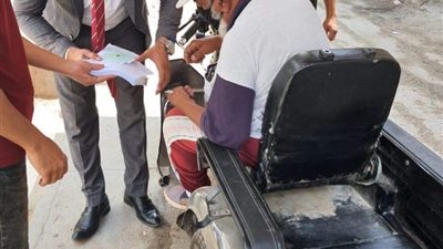 رئيس لجنة بالإسماعيلية يخرج لمساعدة ناخب من ذوي الاحتياجات الخاصة للإدلاء بصوته