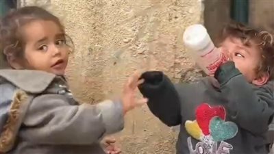 مشهد يبكي قلوب العالم الصامت.. صغيرة فلسطينية تطعم شقيقتها الحليب في علبة سائل تنظيف