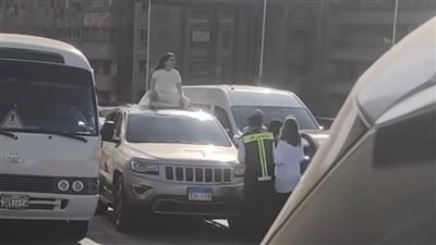كأنها بتلعب يوجا.. فتاة تجلس أعلى سقف سيارة بكوبري أكتوبر تسبب زحاما مروريا