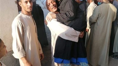 ناخب يحمل والدته للإدلاء بصوتها في انتخابات مجلس النواب بقنا