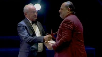 ساويرس يُسلم خالد الصاوي جائزة الإنجاز الإبداعي في ختام “الجونة السينمائي”