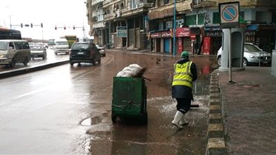 ليس اختصاصهم.. عمال النظافة يساهمون في كسح مياه الأمطار من شوارع الإسكندرية (صور)