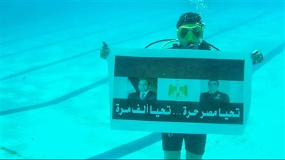 تحيا مصر 1000 مرة.. نجل الشهيد منسي يرفع علم مصر تحت الماء